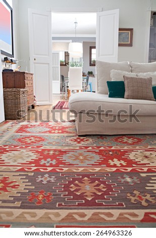 Low perspective still life of interior design home living room with a white sofa with cushions, and quality carpets, home interior. Aspirational and relaxing home family room, indoors lifestyle.