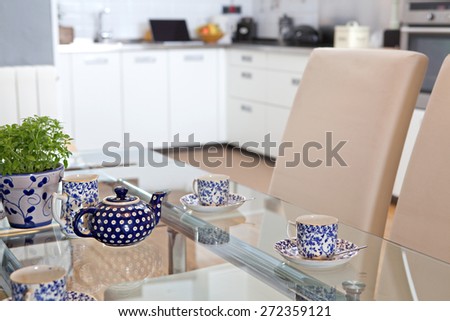 Still life interior design home dining room and kitchen view of a tray with teapot set serving of hot drinking tea in a spacious stylish house. Aspirational home dining room and kitchen, lifestyle.