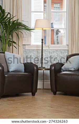 Still life interior home reading room with comfortable quality leather armchairs in a spacious stylish house. Aspirational and relaxing home with sofas by a window, indoors living lifestyle.