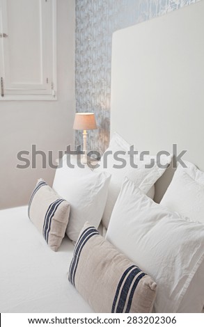 Still life view of an aspirational luxury home bedroom in a quality family home, interior design. Stylish bed in home room with a closed window and a pattern wallpaper with nature details, indoors.