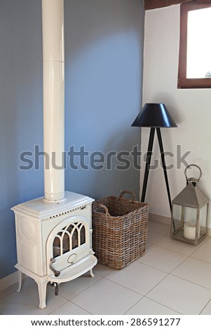 Still life home interior view of a traditional quality wrought iron fireplace stove in a stylish home living room, indoors. Elegant stylish standing lamp, empty space, aspirational lifestyle.