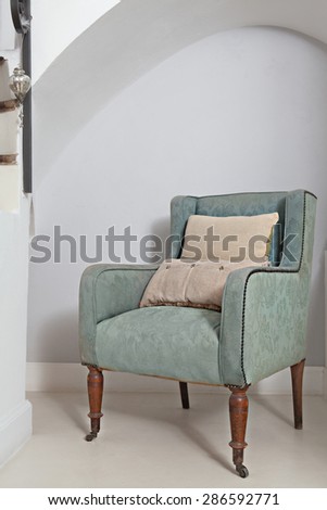 Still life home interior view of a traditional quality and luxurious wooden armchair with cushions in a stylish home living room, indoors. Elegant reading room with upholstery chair, empty space.