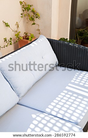 Still life view of a home outdoors living room and terrace garden sitting and relaxing area with a comfortable wicker sofa, in stylish house, indoors and outdoors. Home relaxing living, empty space.