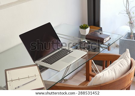 Still life view of a home office room with a laptop computer and a smart phone, house interior. Working from home technology in a home work desk, indoors. High technology lifestyle workplace.