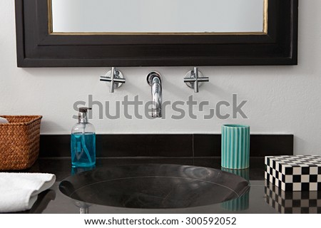 Still life view of a quality luxurious bathroom with a black marble elegant expensive sink in an exclusive bachelor home, bath interior. Masculine hotel bathroom for travelers, indoors.