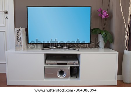 Still life view of a large home entertainment flat screen tv in a modern high technology house, interior. Elegant luxurious quality home cinema smart television with a blue screen, stylish indoors.