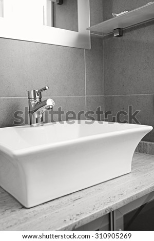 Black and white still life view of a new sink with silver tap in a stylish bathroom in quality design home, interior. Bath room and washing facilities in hotel room, travel and aspirational lifestyle.