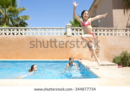 Portrait of joyful child boy having fun by swimming pool in home garden summer holiday, smiling with wet hair in swimwear outdoors playing with water pistol. Active kids lifestyle exterior vacation.