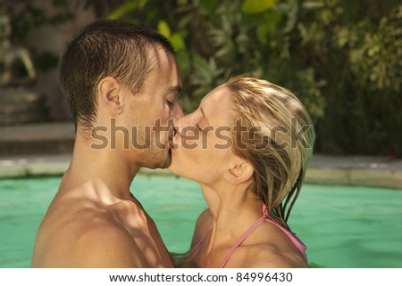 Close-up of a couple kissing in a swimming pool, on holiday.