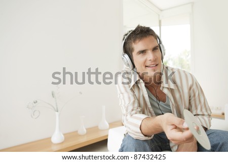 Man listening to music at home, using headphones