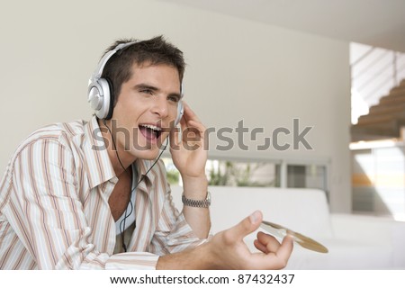 Close up of a man singing to music in house's living room.