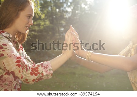 Teenage girl touching hands in the forest.