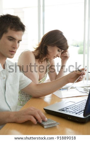 Man and woman working on finances at home.
