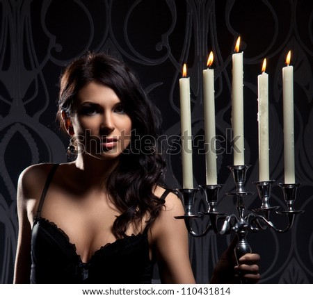 Fashion shoot of young sexy woman with a candles