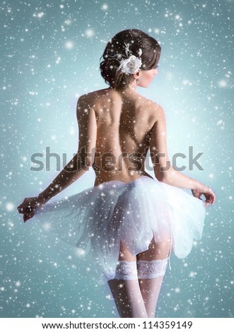 Young beautiful ballet dancer over Christmas background