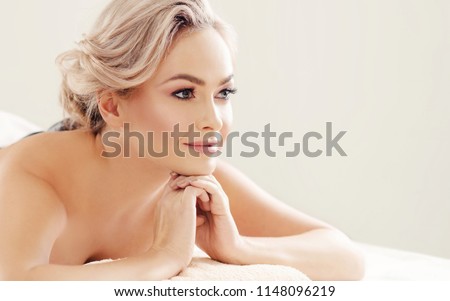 Beautiful and healthy blond woman getting spa therapy and massaging treatments.