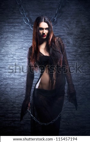 Halloween concept: young and sexy witch makes the witchcraft in the dungeon