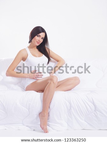 Young attractive pregnant woman with the beautiful belly over white background