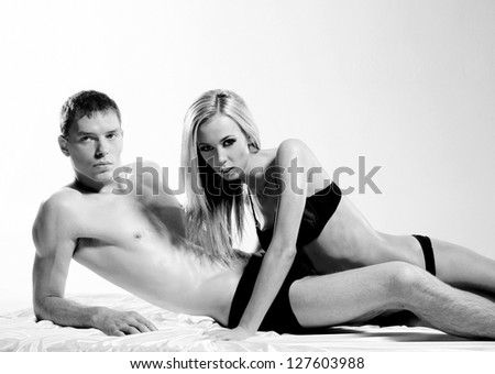 Black and white portrait of young sexy couple over white background