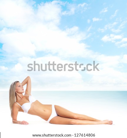 Young, healthy and attractive woman over the sea and sky background