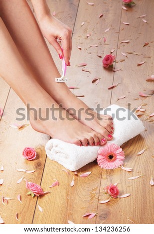 Woman shaving her legs over the spa background