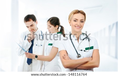 Team of young and smart medical workers over abstract hospital background