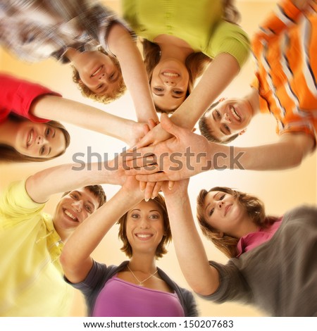 Team Of Smiling Teens Staying Together And Looking At Camera