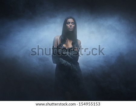 Young, sexy and beautiful woman over smoky background
