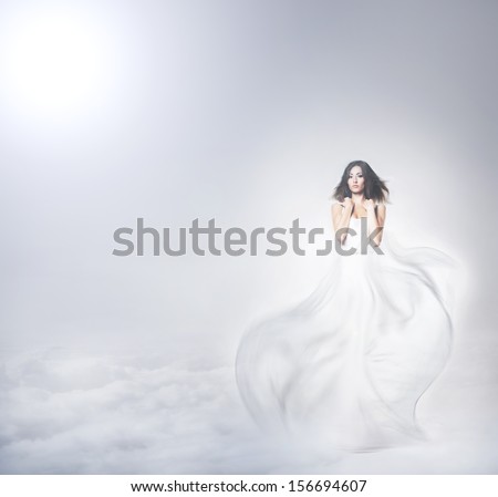 Young and beautiful angel woman in blowing dress over the heaven background