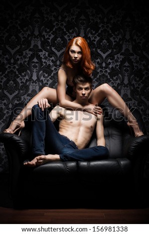 Young And Beautiful Couple On The Leather Sofa