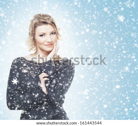 Portrait of young attractive woman in winter dress over the Christmas background