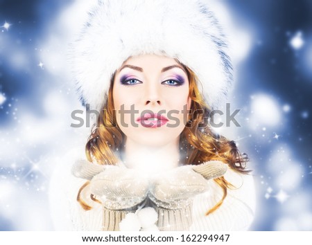 Young and beautiful woman in traditional winter dress over blue background