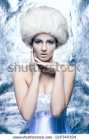 Glamour and bizarre portrait of young and beautiful woman in creative winter style
