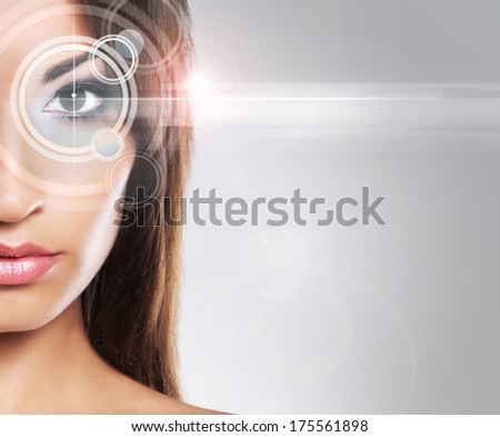 Young and attractive woman from future with a laser hologram on her eyes (ophthalmology and eye scanning technology concept).
