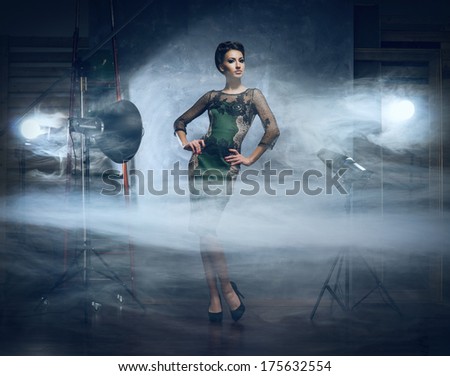 Young and emotional woman in fashion dress over glamour background (studio backstage)