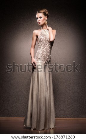 Young, beautiful and rich woman in jewels of gold and stones over luxury background