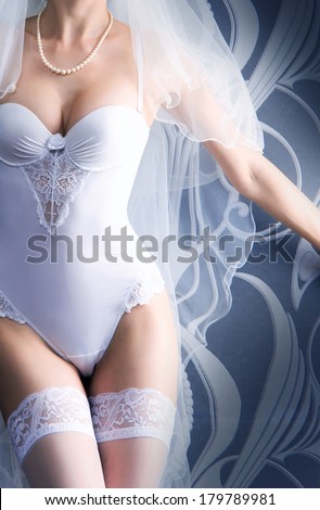 Perfect female body in sexy bridal lingerie over grey background