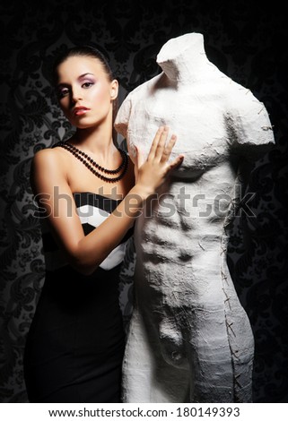 Young, rich and beautiful woman with the mannequin over the vintage background