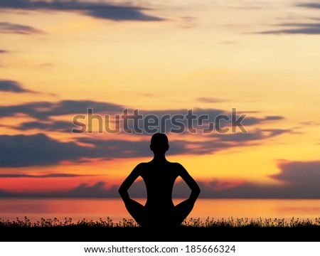 Sunset meditation. Silhouette of a woman doing yoga exercise.