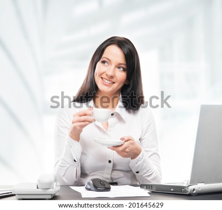 Young and attractive business woman drinking morning coffee in office