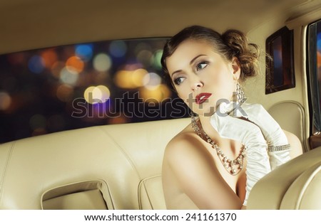 Young and beautiful celebrity woman sitting in a luxury car