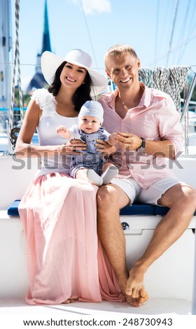 Young family on a sailing boat. Mother, father and a baby.