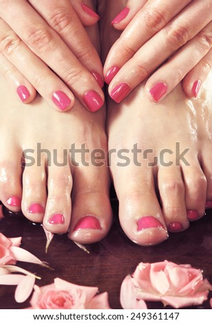 Legs, flowers, petals and ceramic bowl. Spa, recreation and skin care concept.