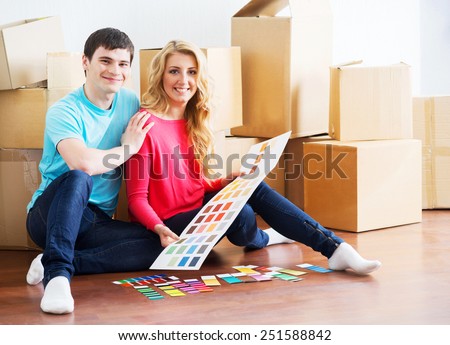 Young couple moving in a new home. Wife and husband selecting a new color for a condo.