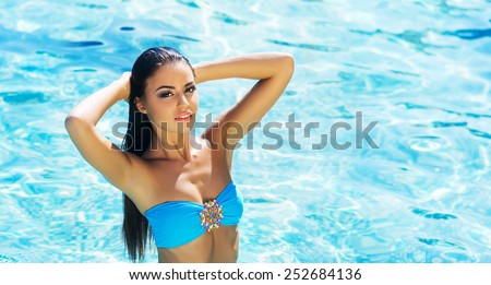 Beautiful, active and sporty girl swimming in a pool at summer