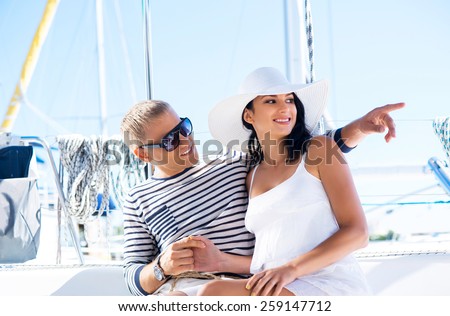 Young, rich and attractive couple on a sailing boat