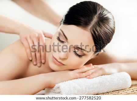 Young and healthy woman in spa salon. Traditional Swedish massage therapy and beauty treatments.