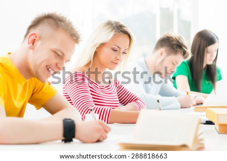 Group of teenage students at the exam in the auditorium