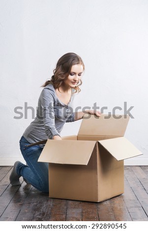 Young and beautiful woman with a big box. Moving and shopping concepts.
