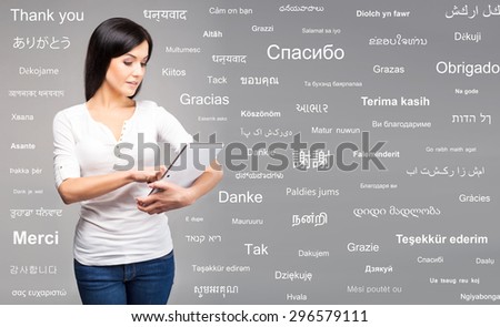 Teenager girl with a tablet computer. Different world languages concept.